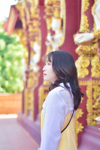 Portrait of young woman standing in greenhouse