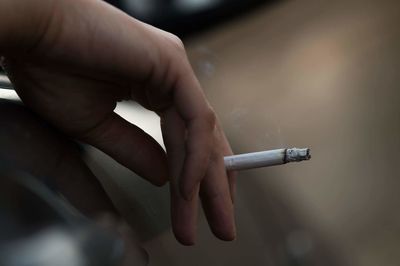 Close-up of hand holding cigarette