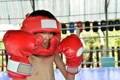 Portrait of shirtless boy in practicing boxing