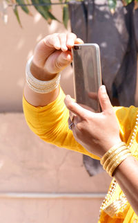 Midsection of man using mobile phone