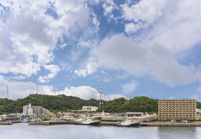Scenic view of river by buildings against sky