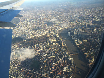 Aerial view of cityscape seen through airplane glass window