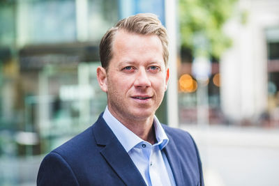 Portrait of mature businessman standing in city