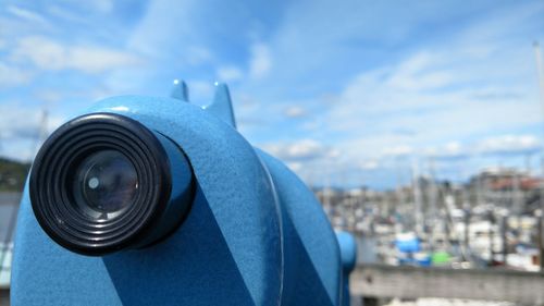 Close-up of person holding camera against sky