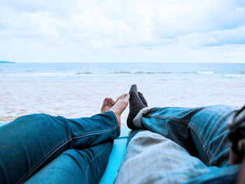 Low section of man relaxing on beach