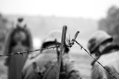 Close-up of barbed wire on fence against sky