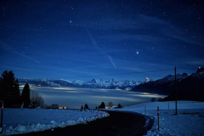 Scenic view of lake and mountains during winter at night