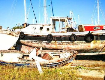 Boats moored at harbor against sky