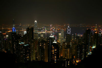 Illuminated cityscape against sky at night