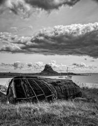 Abandoned ship on field against sky