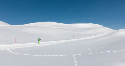 Cross-country skier alone in the middle of the snowy slopes