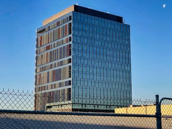 Low angle view of modern building against clear blue sky