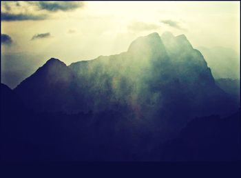 Scenic view of mountains against cloudy sky