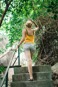 Full length of woman wearing sunglasses against tree