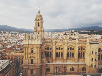 Buildings in city against cloudy sky