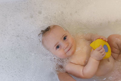 Portrait of boy with arms outstretched in bathroom