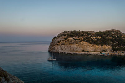 Scenic view of rock formation in sea against sky