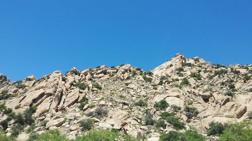 Scenic view of rocky mountains against clear blue sky