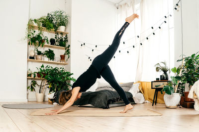 Full length of woman exercising at home