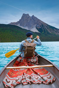 Rear view of man on boat against mountains