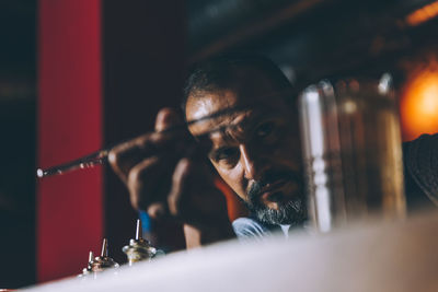 Bartender preparing cocktail at counter in bar