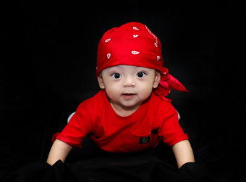 Portrait of cute boy against black background