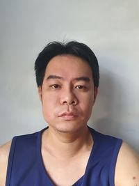 Portrait of young man against wall