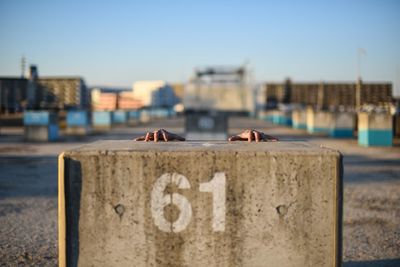 Person hiding behind concrete block at commercial dock