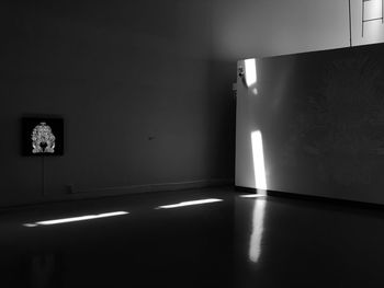 Illuminated lamp on wall of house