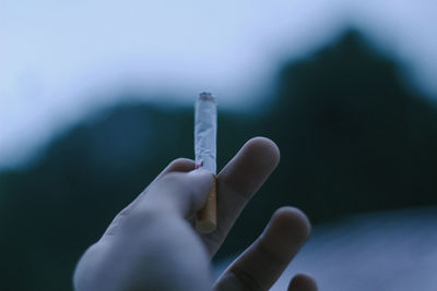 Close-up of hand holding cigarette