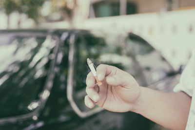 Close-up of hand holding cigarette