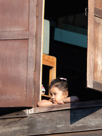 Portrait of boy looking through window