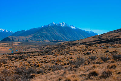 Scenic view of snowcapped mountains against clear blue sky