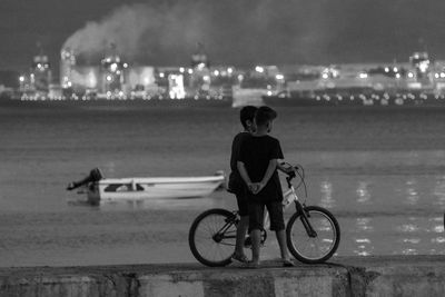 Rear view of man riding bicycle at night