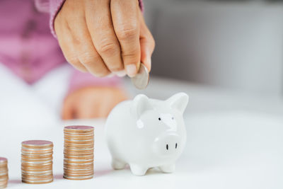 Close-up of hand holding coins on table