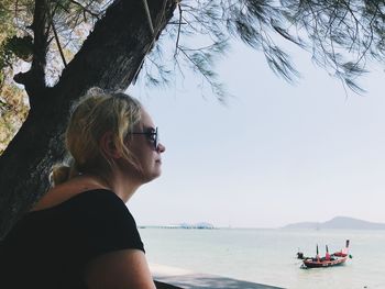 Side view of woman in sunglasses against sky