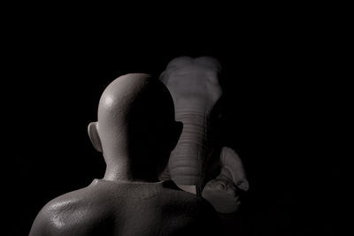 Close-up of shirtless boy against black background