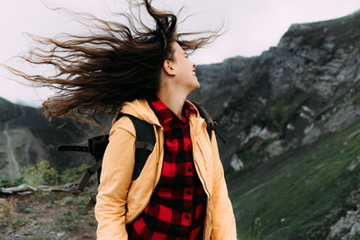 Young happy laughing carefree woman with hair blowing in the wind.