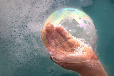 Close-up of hand holding glass of water