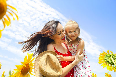 Happy woman with arms outstretched against blue sky