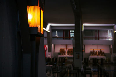 Empty chairs and tables in illuminated building