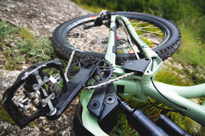 Mountain bike lies on the mountainside. a tired bicycle lies on a stone in the grass on the side of