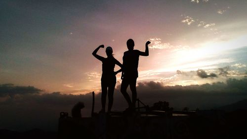 Silhouette men against sky during sunset