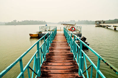 Pier over lake against clear sky