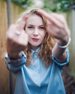 Portrait of young woman making obscene gesture