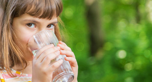 Cute girl drinking water standing on road