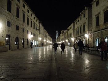 People in illuminated city at night