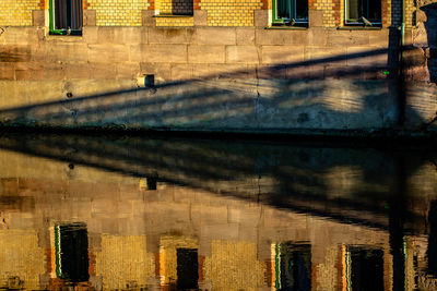 Reflection of building in puddle on street