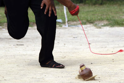 Low section of man playing with spinning top