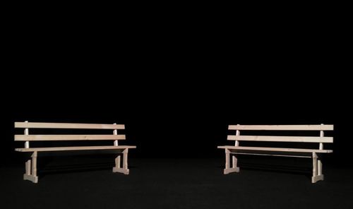 Empty bench against black background